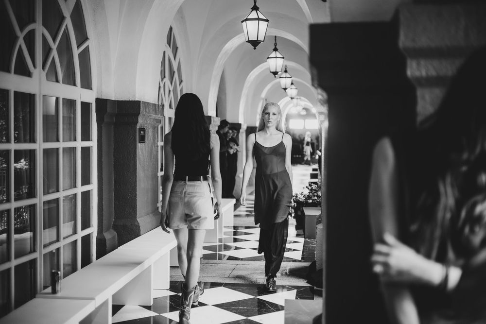 Black and white shot of models walking arched hallway backstage | BTS Fashion Photography by Dario Hudon-Verrelli, Le Café Studio