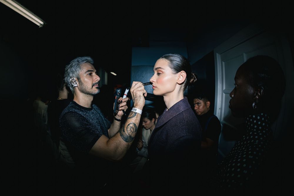 Makeup artist applies final touches backstage before runway | BTS Fashion Photography by Dario Hudon-Verrelli, Le Café Studio