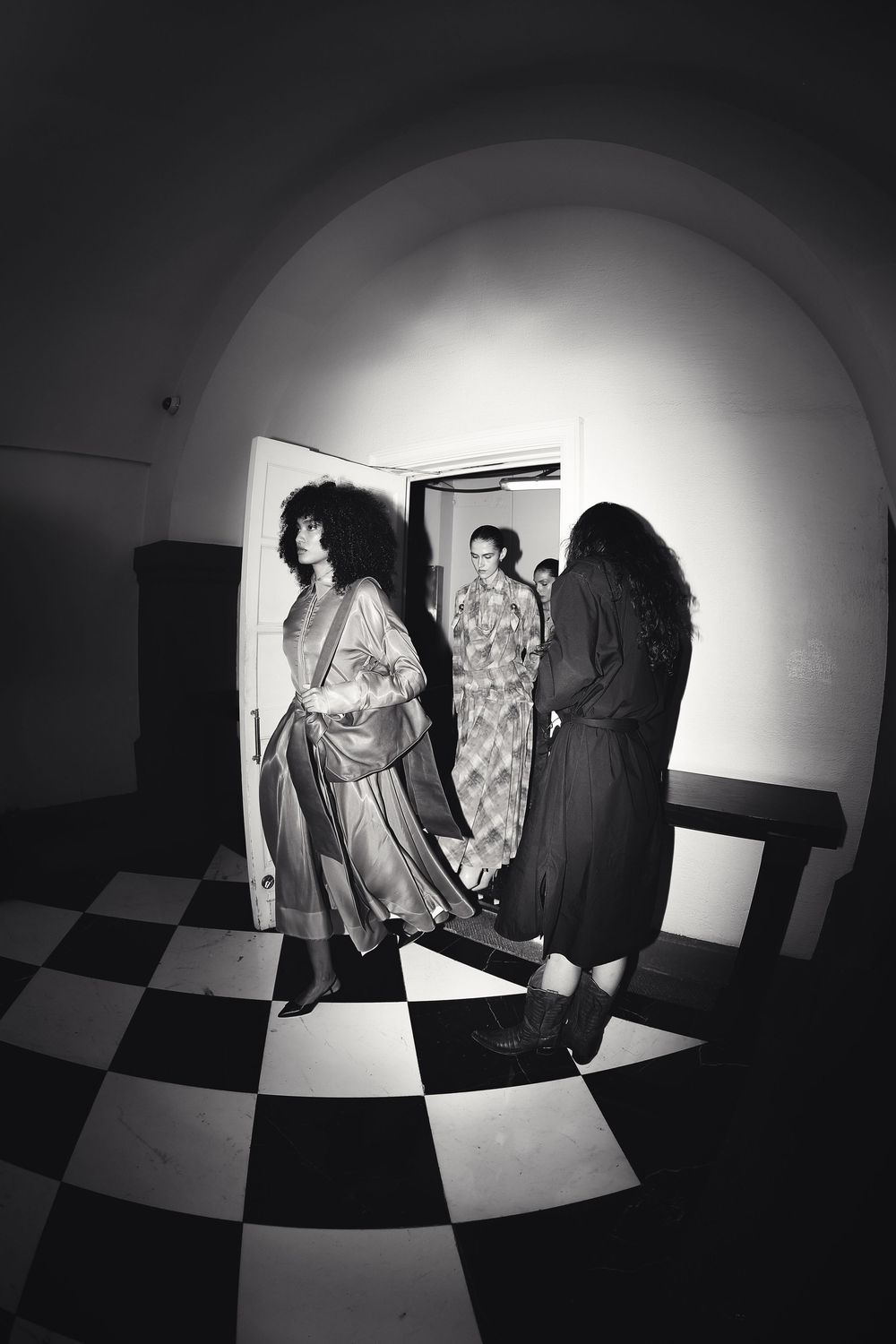 Black and white backstage shot of two models on checkered floor | BTS Fashion Photography by Dario Hudon-Verrelli, Le Café Studio