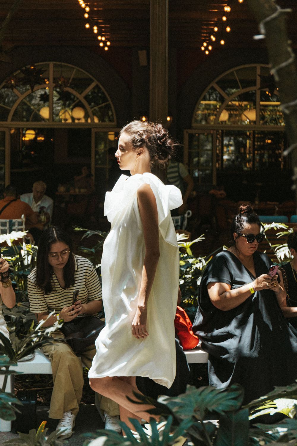 Model in white dress walking runway before audience | Fashion Photography by Dario Hudon-Verrelli, Le Café Studio