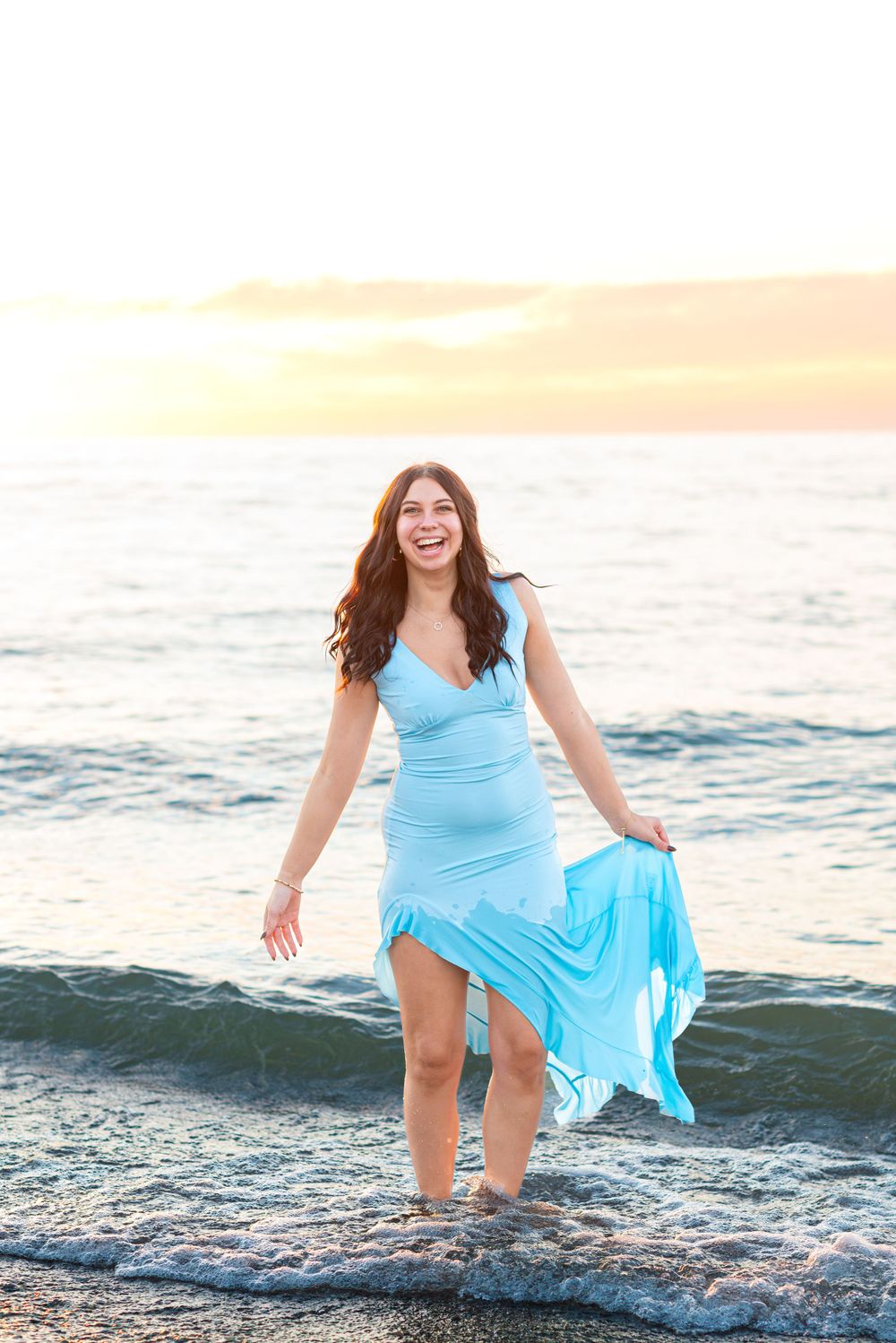 Senior photos in the water at the beach during sunset at Headlands Beach State Park in Mentor, Ohio