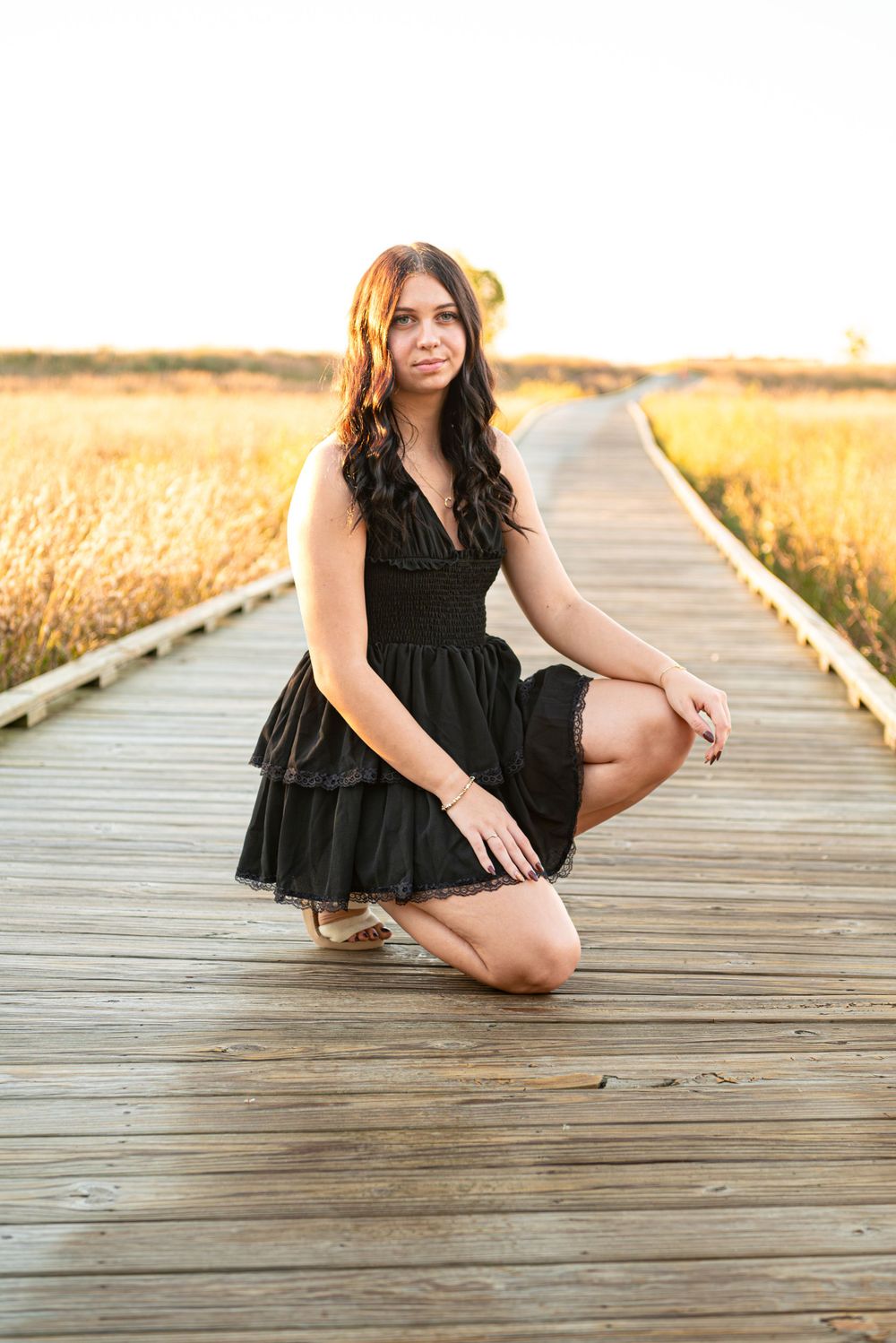 Senior photos sitting on the boardwalk at Headlands Beach State Park in Mentor, Ohio