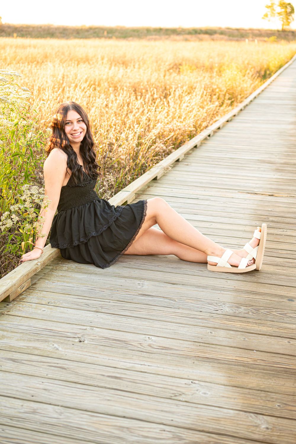 Senior photos sitting on the boardwalk at Headlands Beach State Park in Mentor, Ohio
