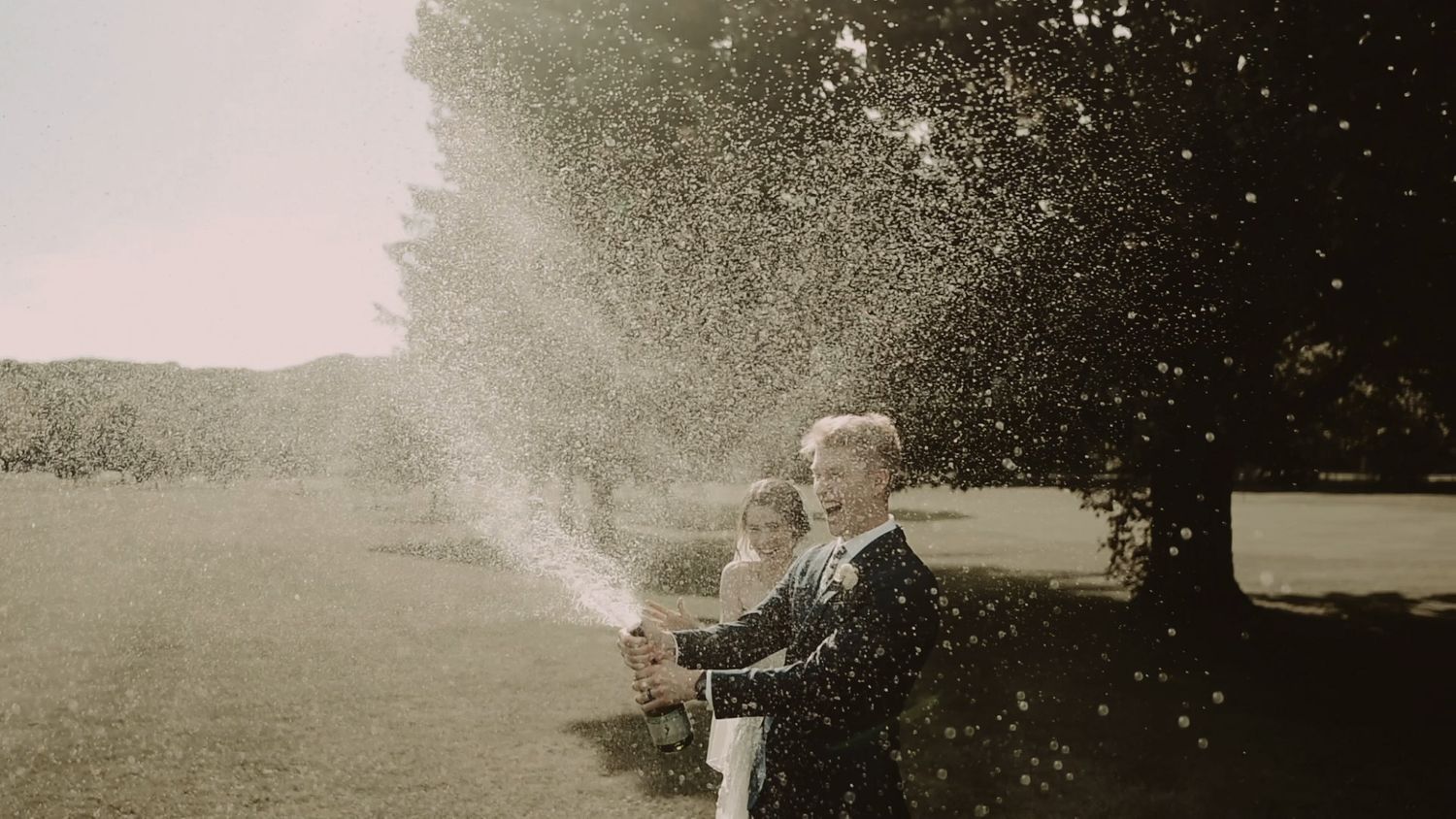 Wedding celebration captured in dreamy sunlit moment outdoors.