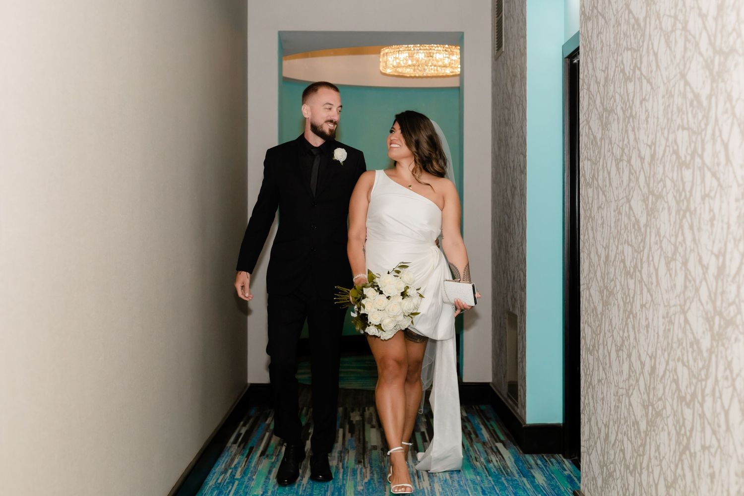 An elegant wedding portrait against modern city architecture and glass buildings.