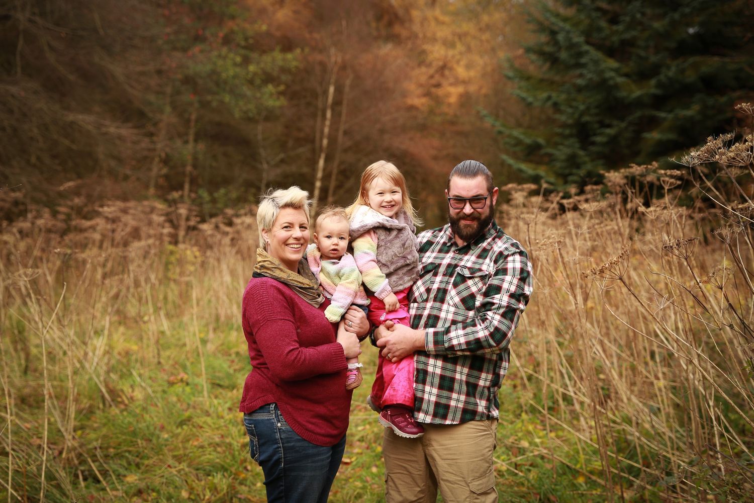 A joyful family enjoying a moment together in the tranquil surroundings of Dunnottar Woods, capturing the beauty of nature and connection