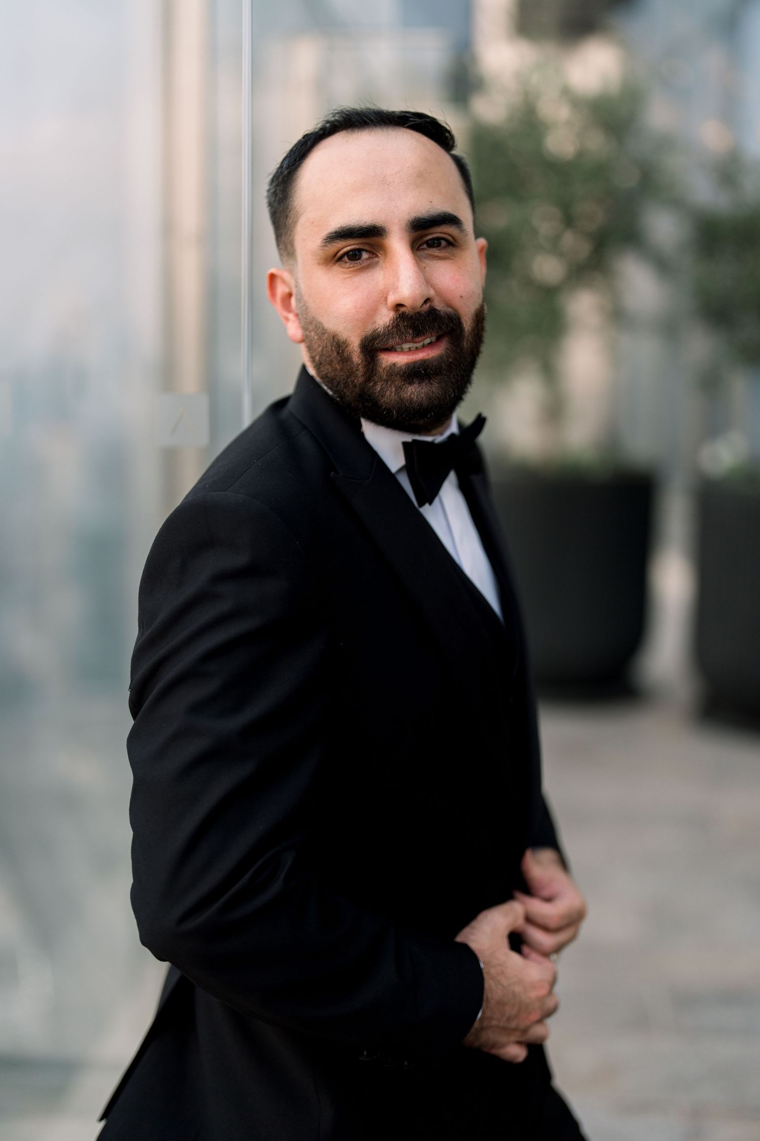 A series of candid shots showing someone in a black suit jacket posing playfully against a blurred background.