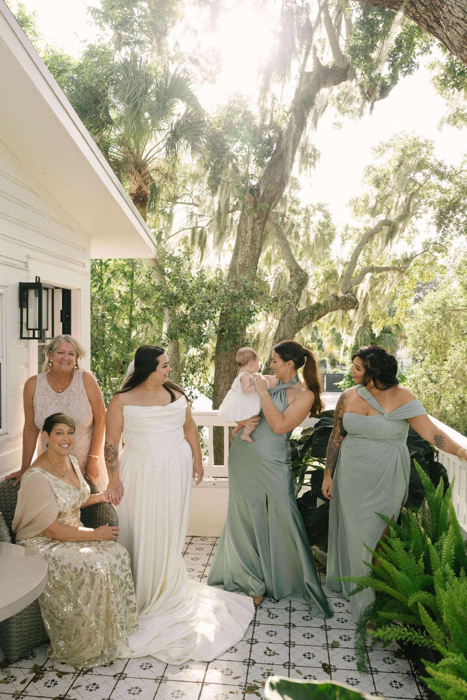 A series of intimate getting ready moments at a wedding showing the bride in a white dress being helped by others.