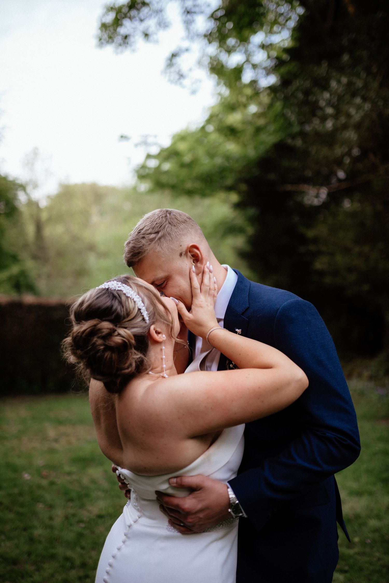 Intimate moment between newlyweds in a natural outdoor setting.