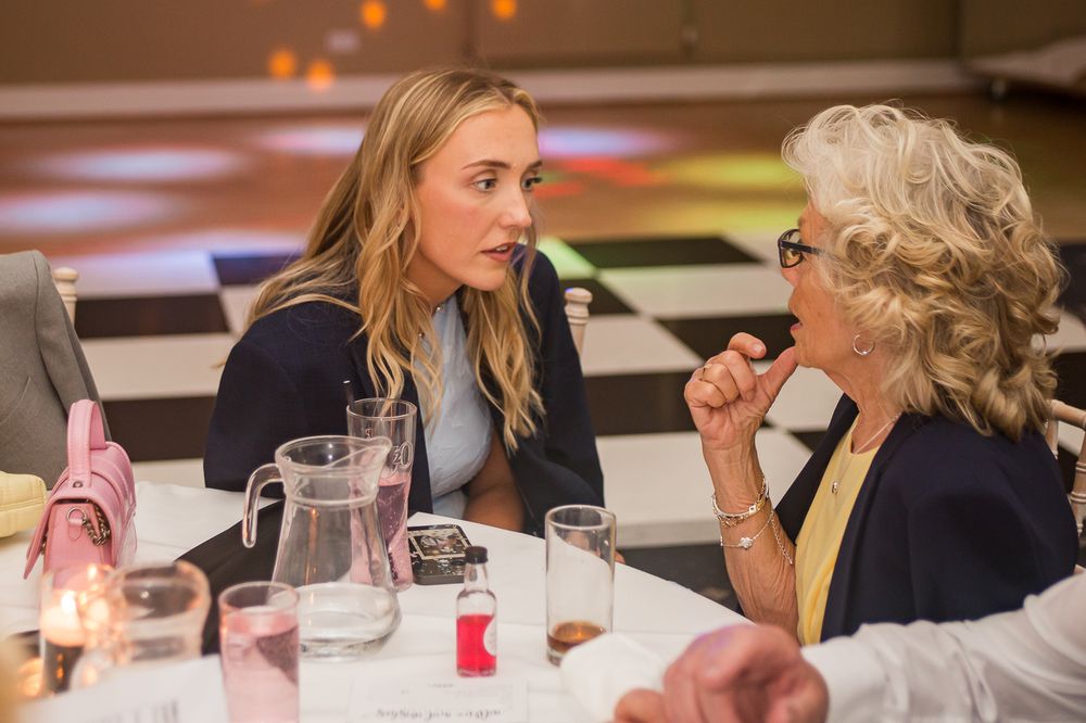 Guests enjoying conversation at a formal dining event.