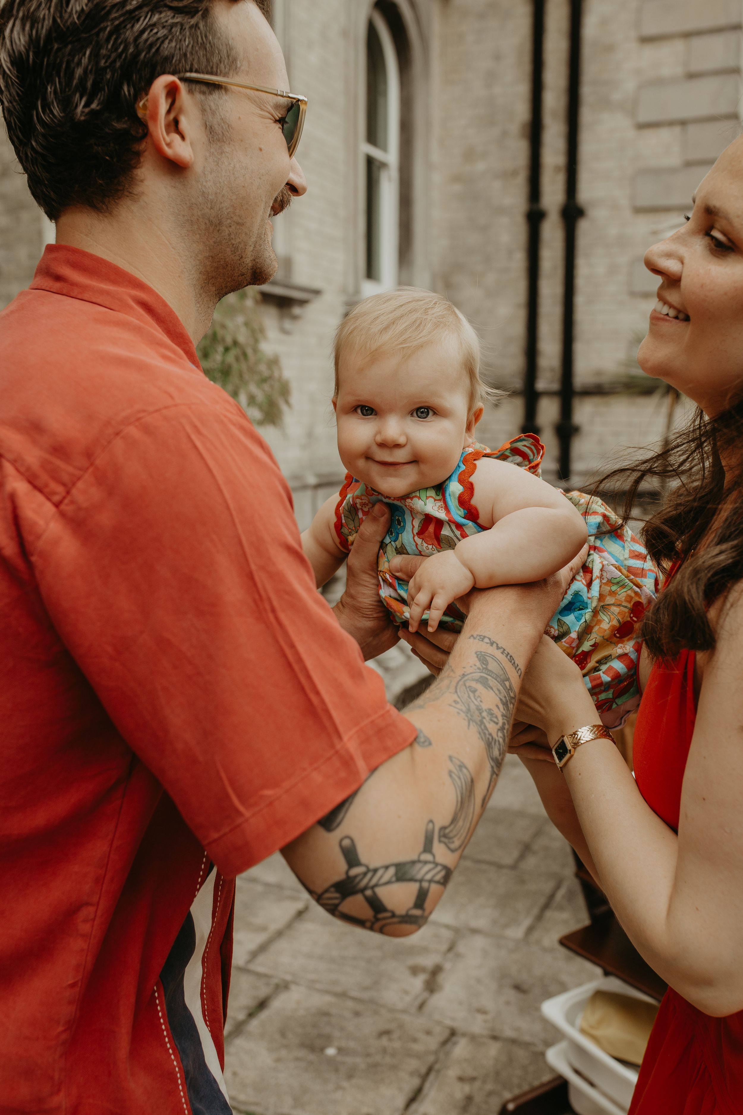 A series of candid photos showing joyful family moments in warm tones against a stone wall backdrop.