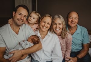 A happy family relaxes together on a couch at home, sharing joyful moments and laughter.