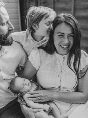 A tender black and white photo series showing intimate family moments of cuddling and laughter together.