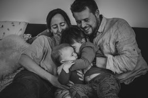 Black and white photographs showing tender family moments of parents and children cuddling and bonding together.