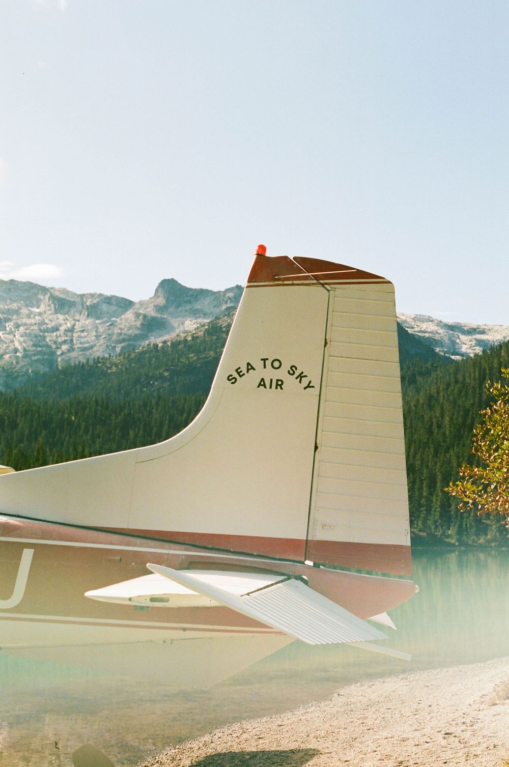 Tail section of a seaplane with 'Sea to Sky Air' text against mountain backdrop.