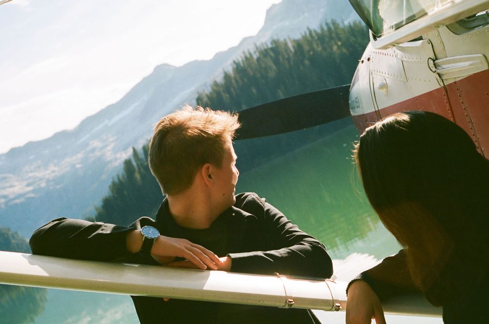 A person gazes out at a scenic mountain lake view from inside a vehicle during a road trip.