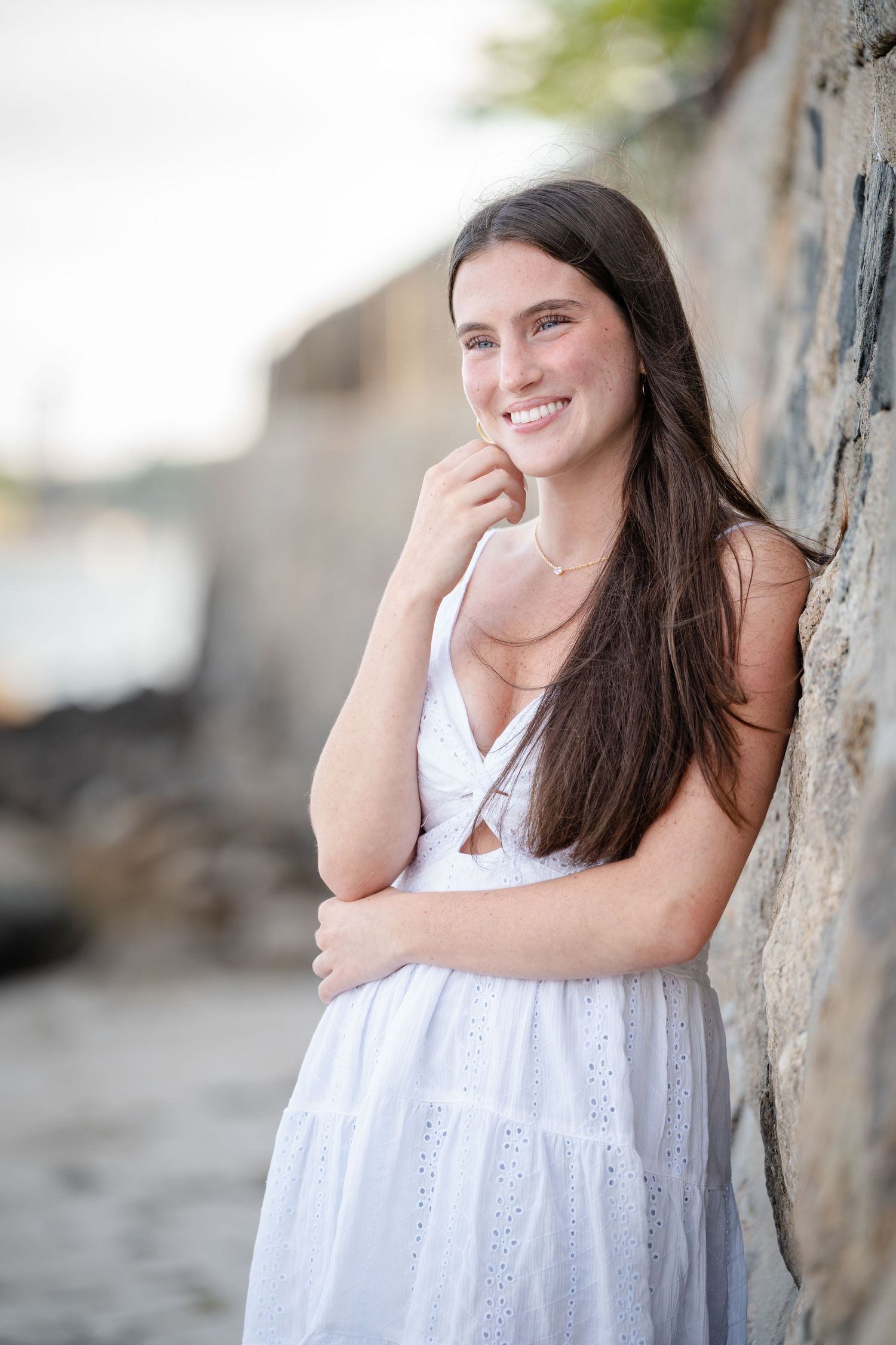 A person in a white summer dress poses against a blurred outdoor background in a series of candid shots.