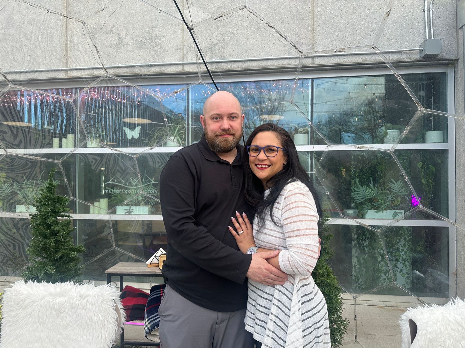 A couple embraces in front of glass windows at multiple locations in a photo collage.