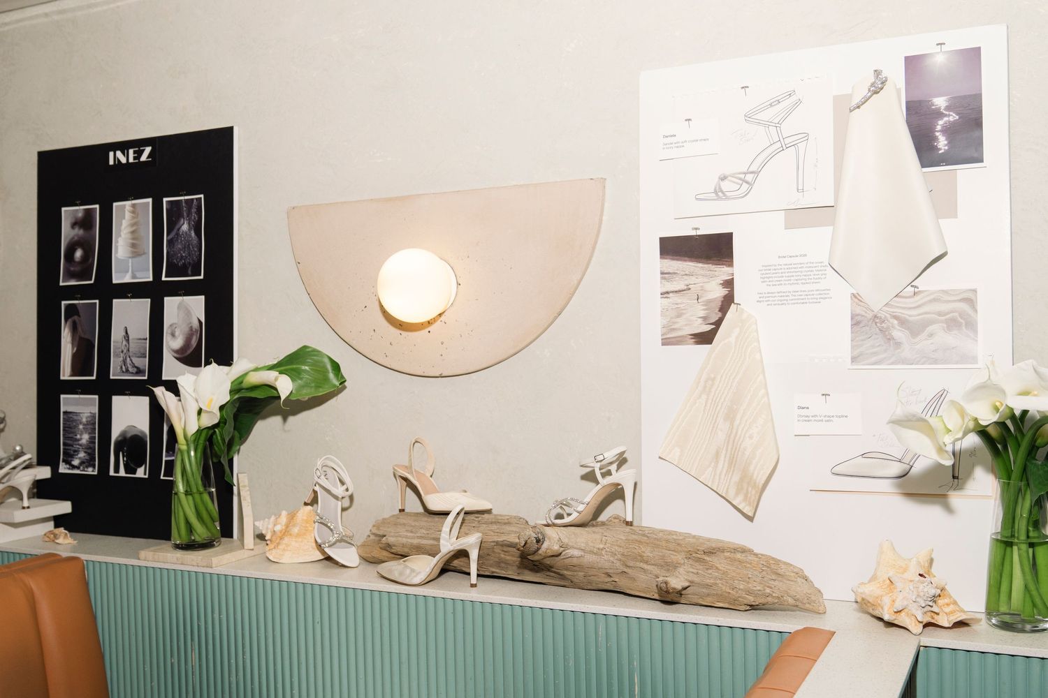 Modern home office setup with white desk, turquoise accent wall, plants and wall art creating a stylish workspace.