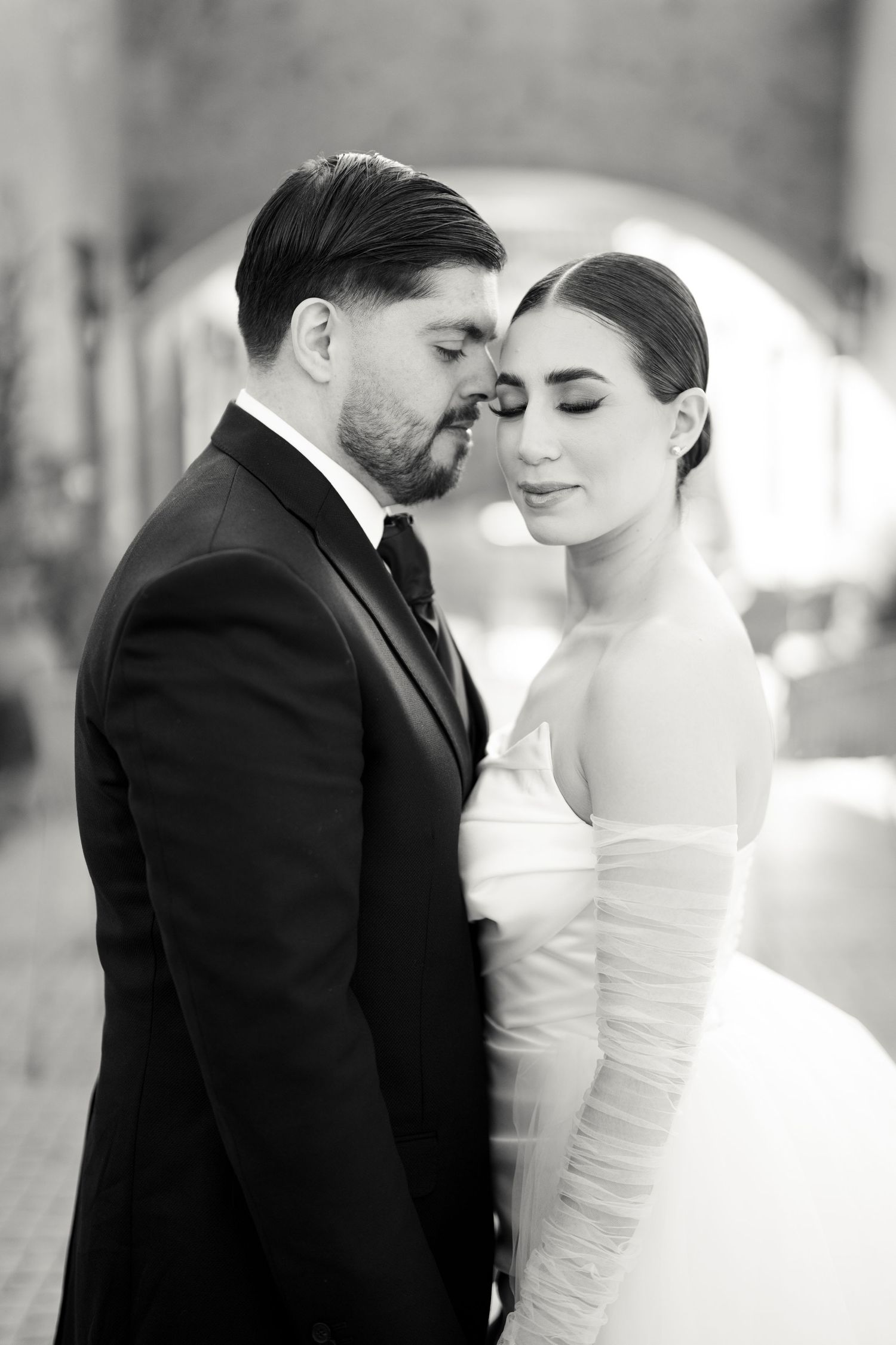 Elegant black and white wedding portraits showing tender moments between newlyweds.