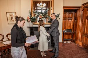A collage of wedding ceremony moments showing people in formal attire exchanging documents in an elegant indoor setting.