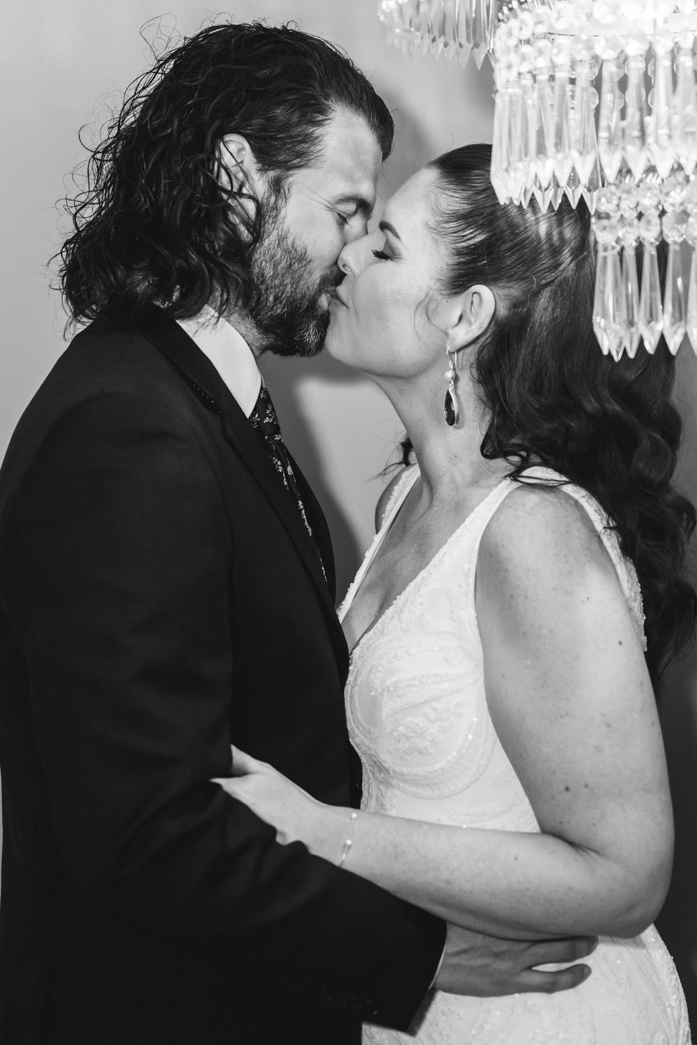 A series of black and white wedding photos showing intimate moments between a couple in formal attire.