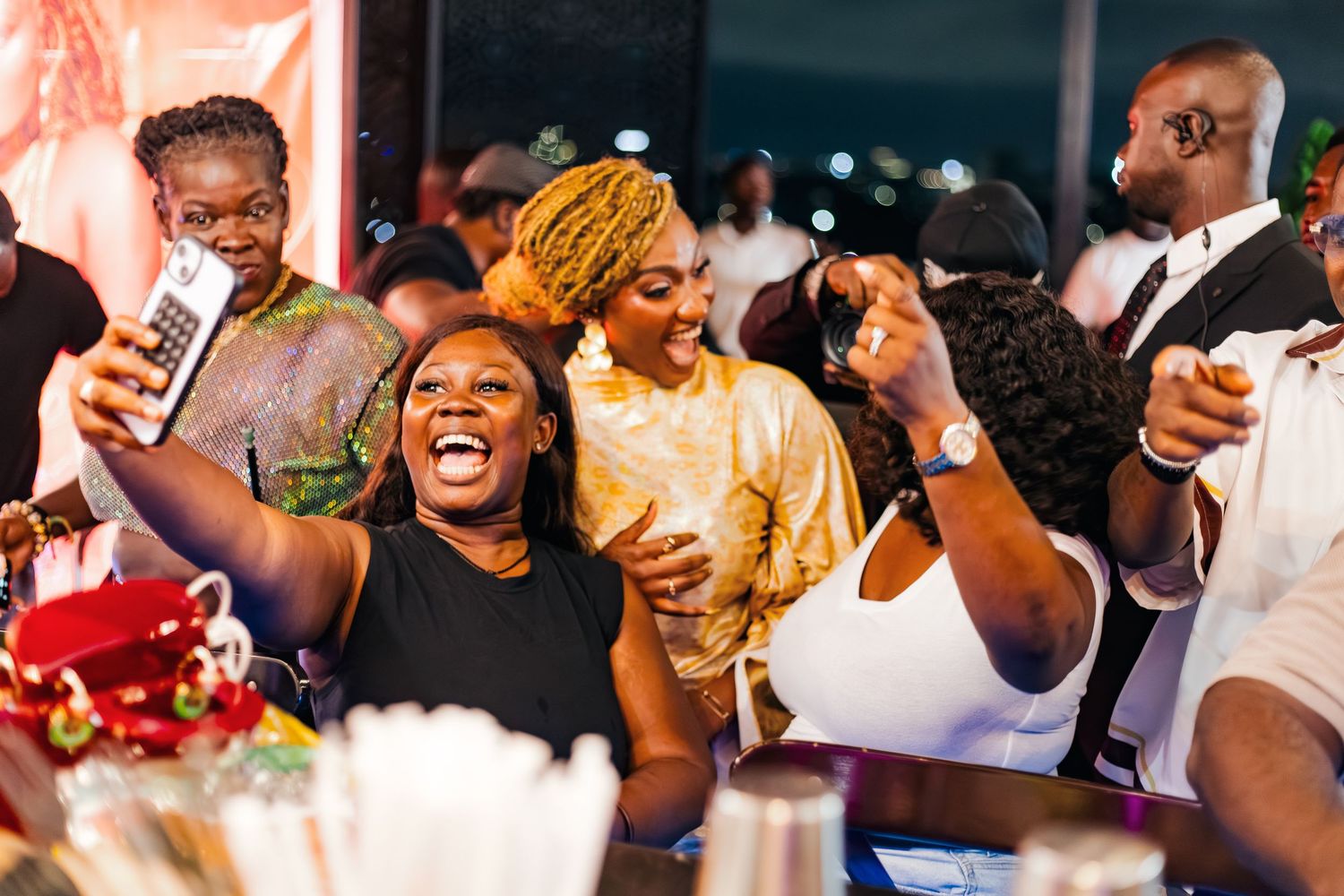 A group of friends laughing and celebrating at an indoor party.