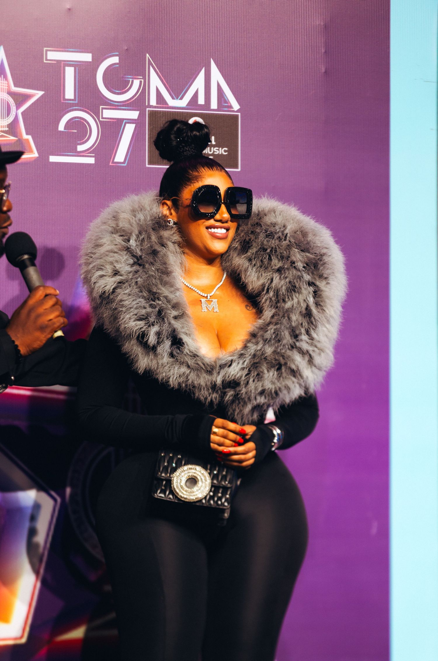 Woman in fur stole and sunglasses smiling at TGMA 27 music awards event.