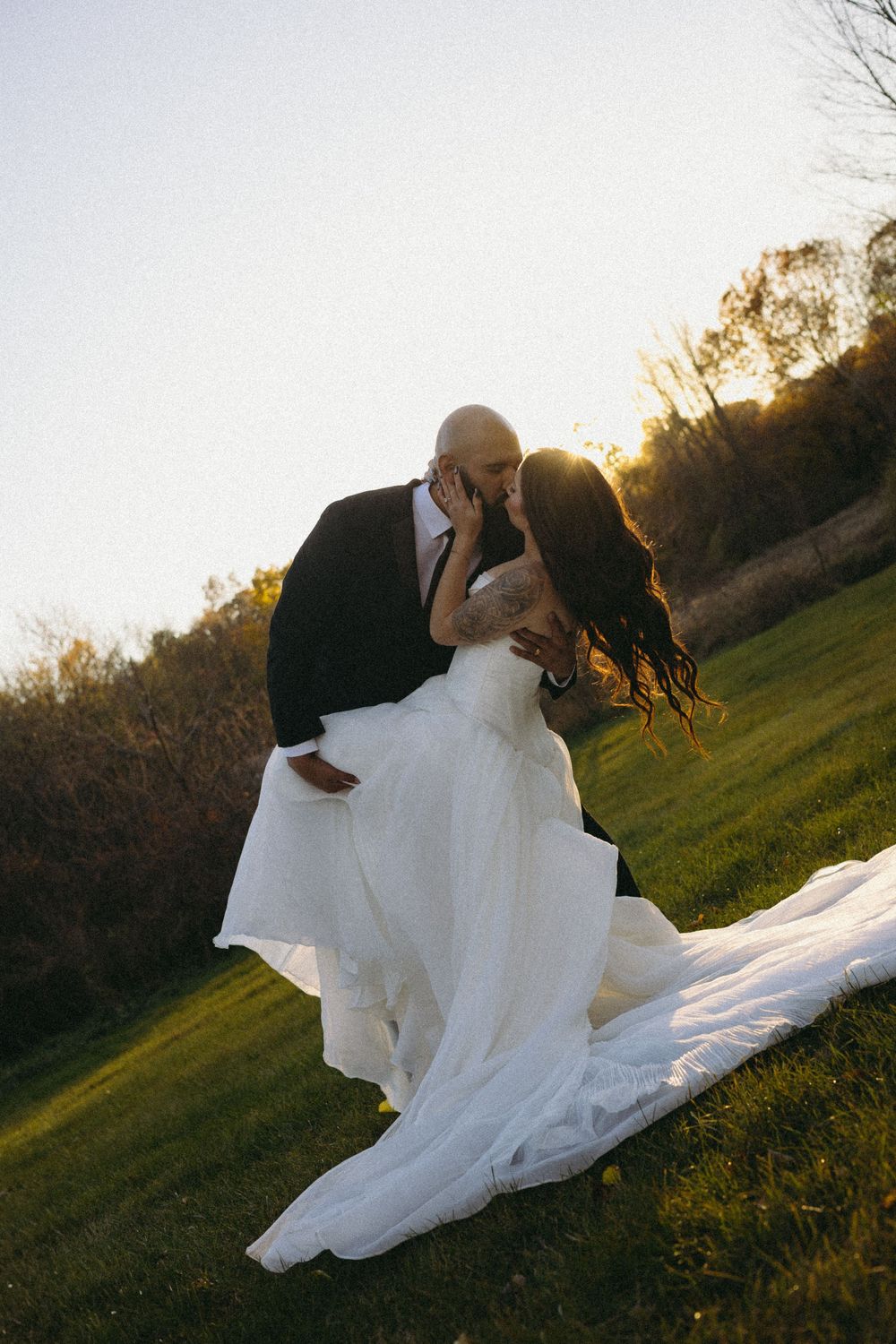 A couple in a black shirt and burgundy shirt embrace in a romantic dance sequence outdoors in Detroit Michigan.