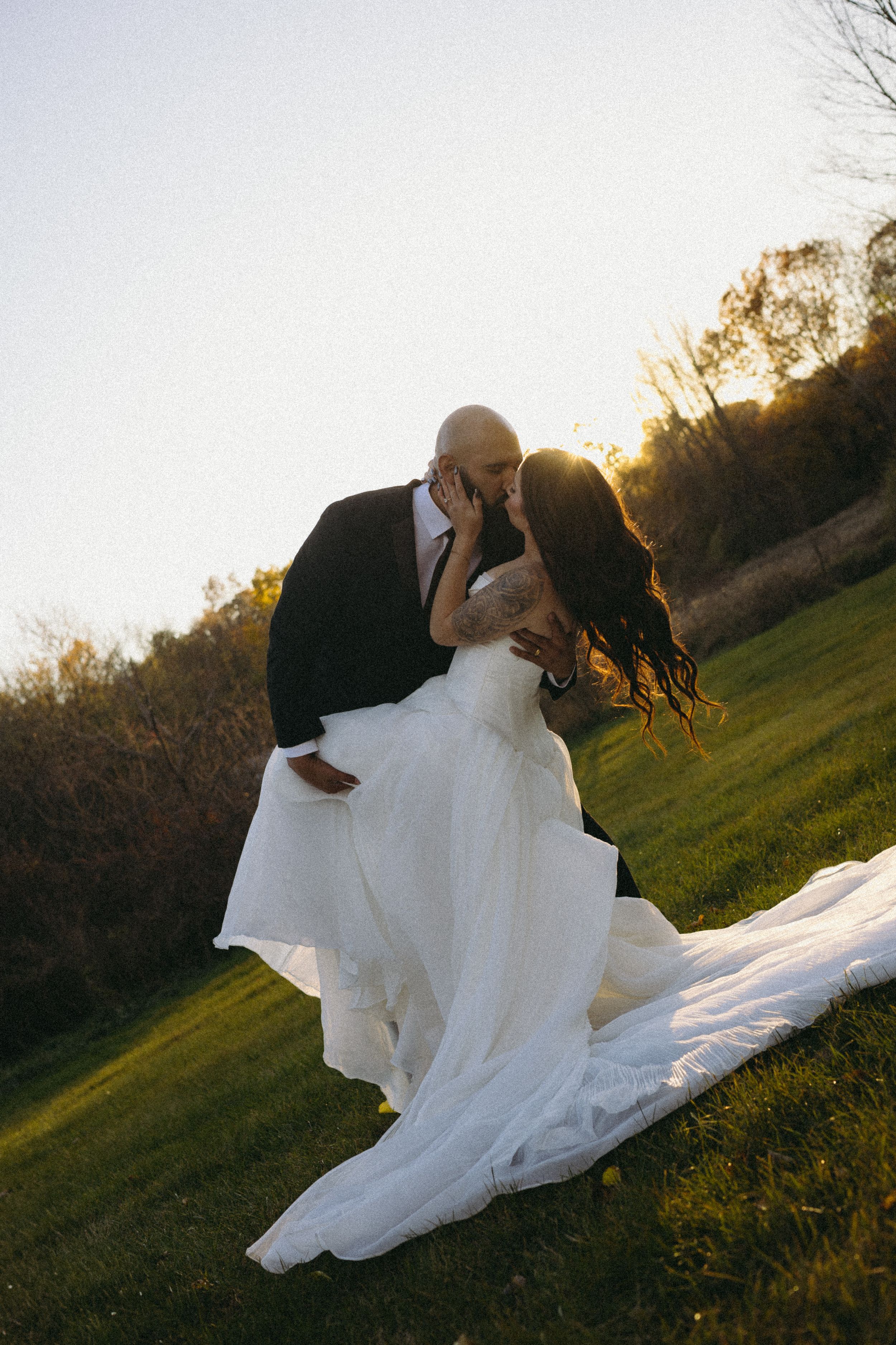 A couple in a black shirt and burgundy shirt embrace in a romantic dance sequence outdoors in Detroit Michigan.