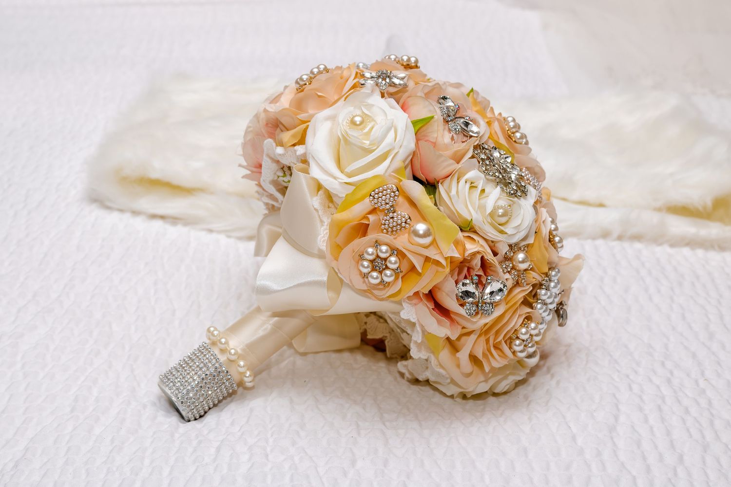 "Bouquet de mariée élégant avec des fleurs et des broches décoratives capturées sur un fond doux par Payo Studio."
