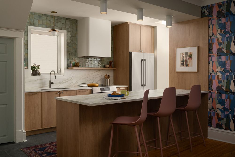 Modern kitchen and dining area with wood cabinetry, bar seating, and floral curtains in a bright open layout.