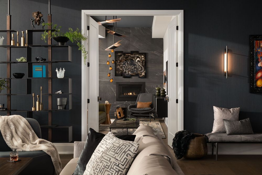 Modern dark gray living room interior with open doorway, shelving unit and plush seating in neutral tones.