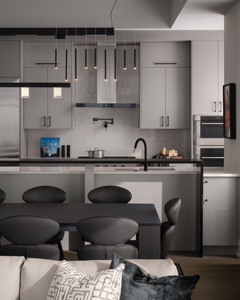 Modern open concept kitchen and living room with black dining chairs and white cabinets in contemporary style.