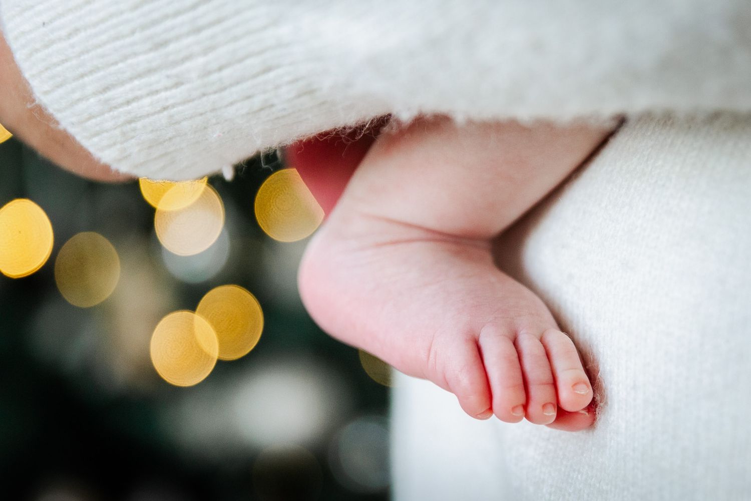 A baby's tiny toes peek from it's mother's embrace. Bristol newborn photographer