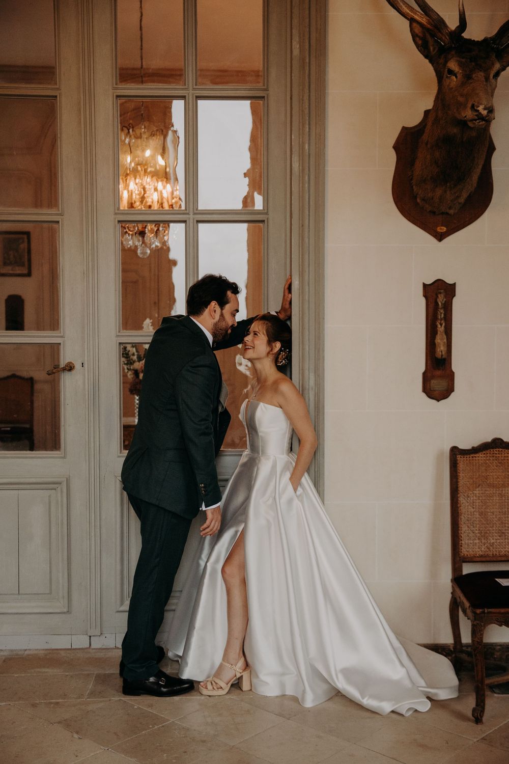 Romantic wedding portraits in an elegant interior with vintage decor and natural lighting.