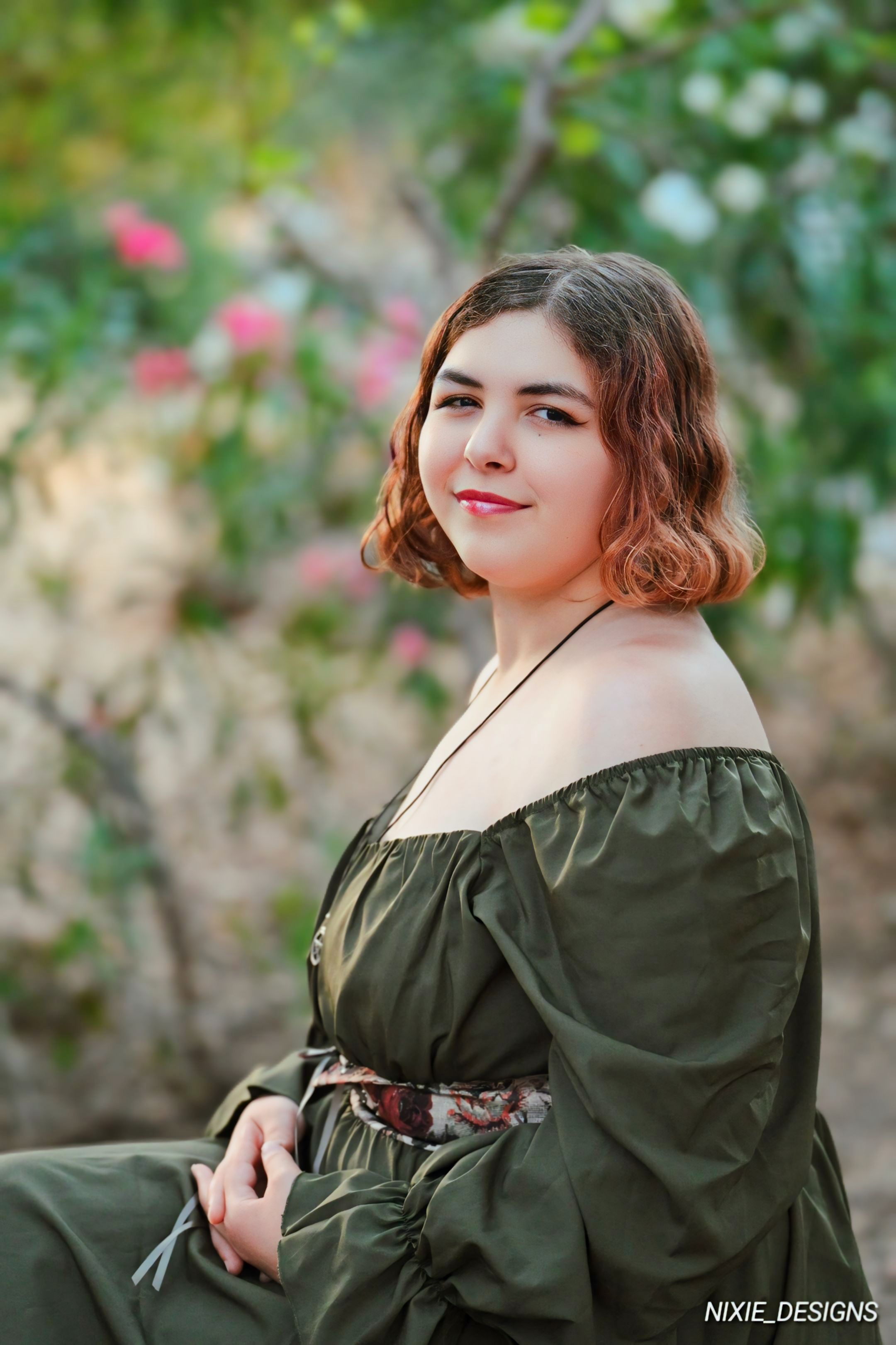 Portrait in a garden setting with bokeh flowers in the background.