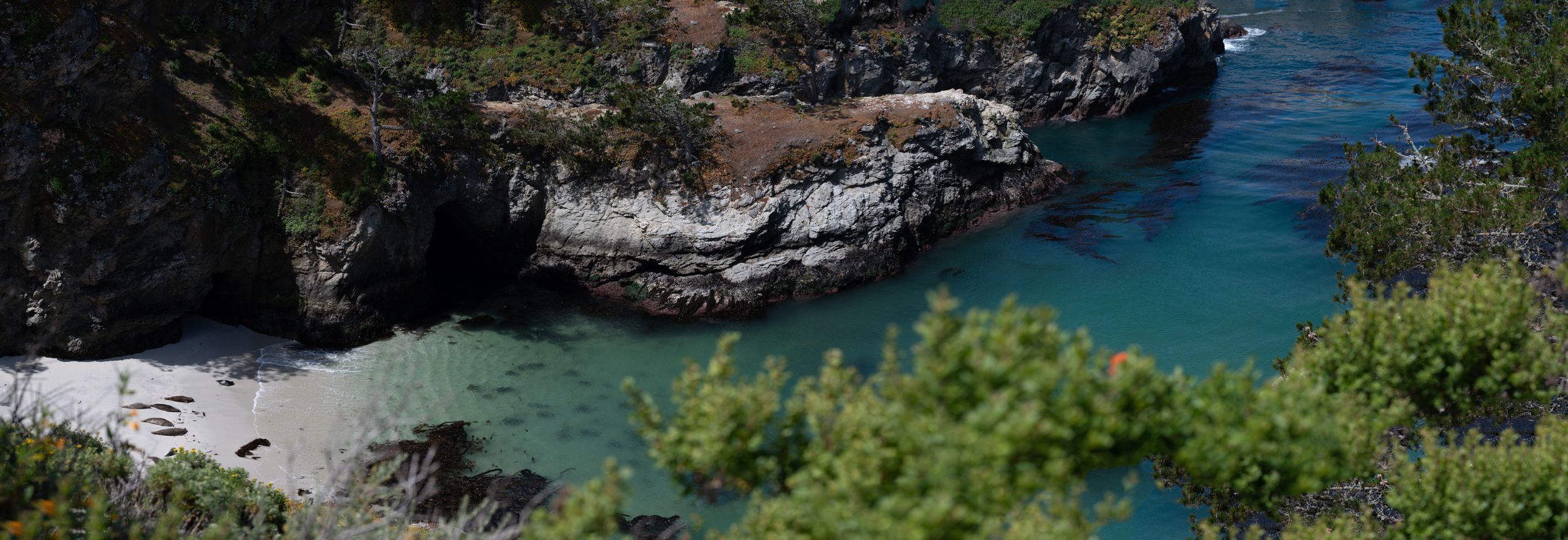 Secluded beach cove with turquoise waters surrounded by rugged cliffs.
