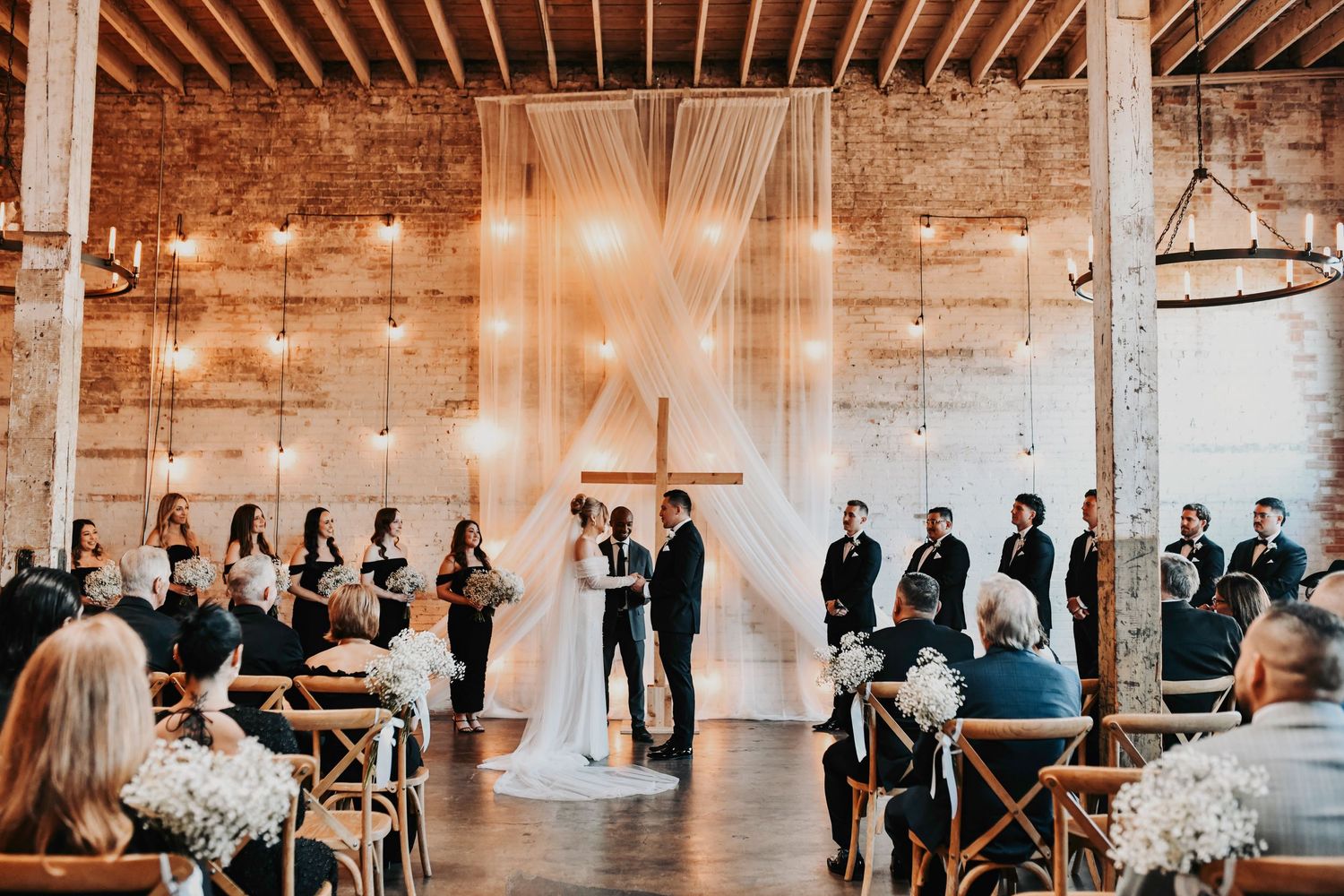 Modern editorial wedding ceremony at Brake & Clutch Warehouse featuring brick walls, timber beams, and lush greenery