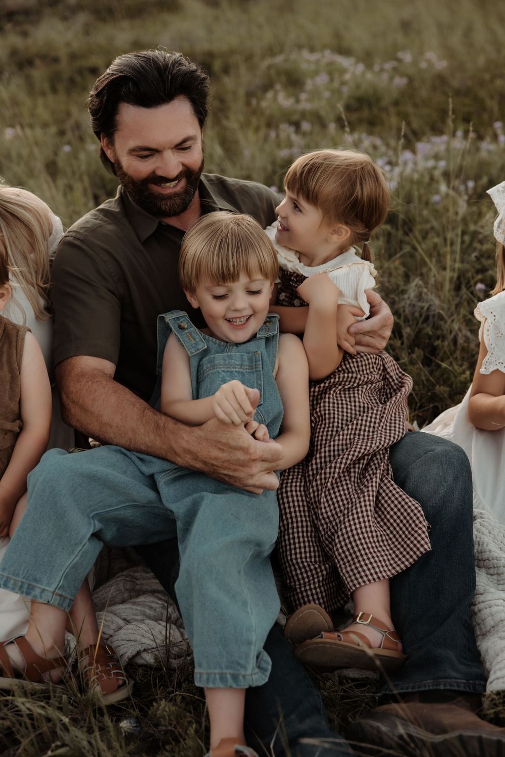 A father tickles his young children during a family photoshoot in calgary alberta