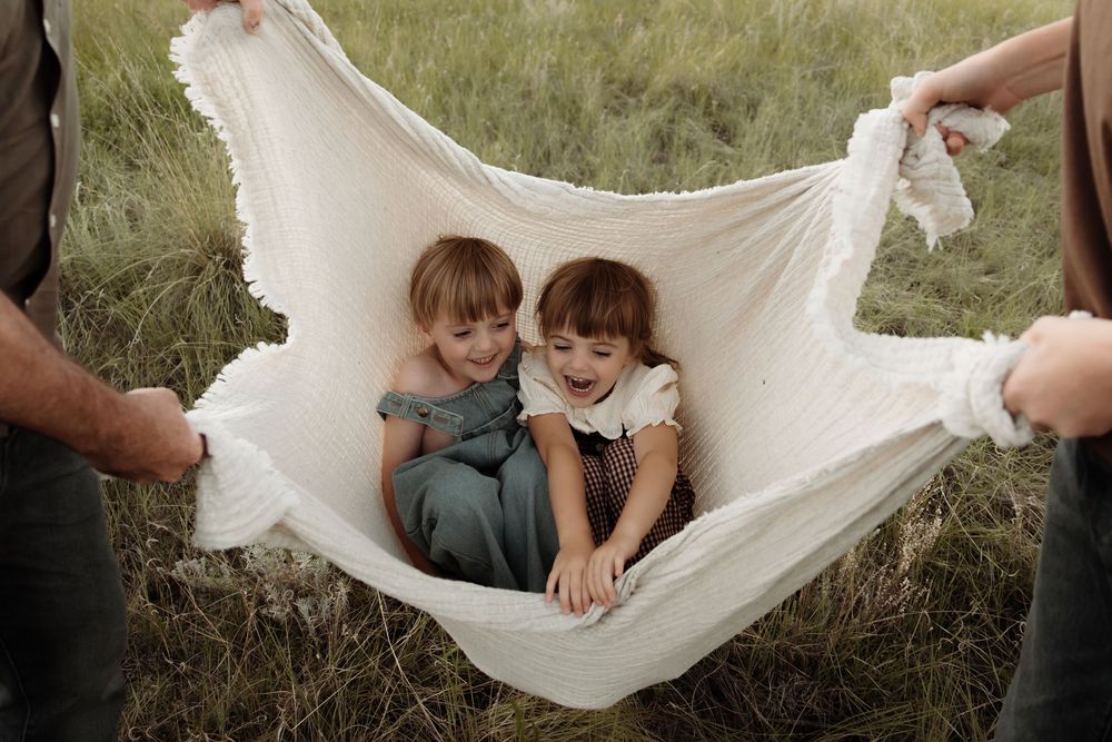 Two young kids play in a blanket swing in calgary alberta