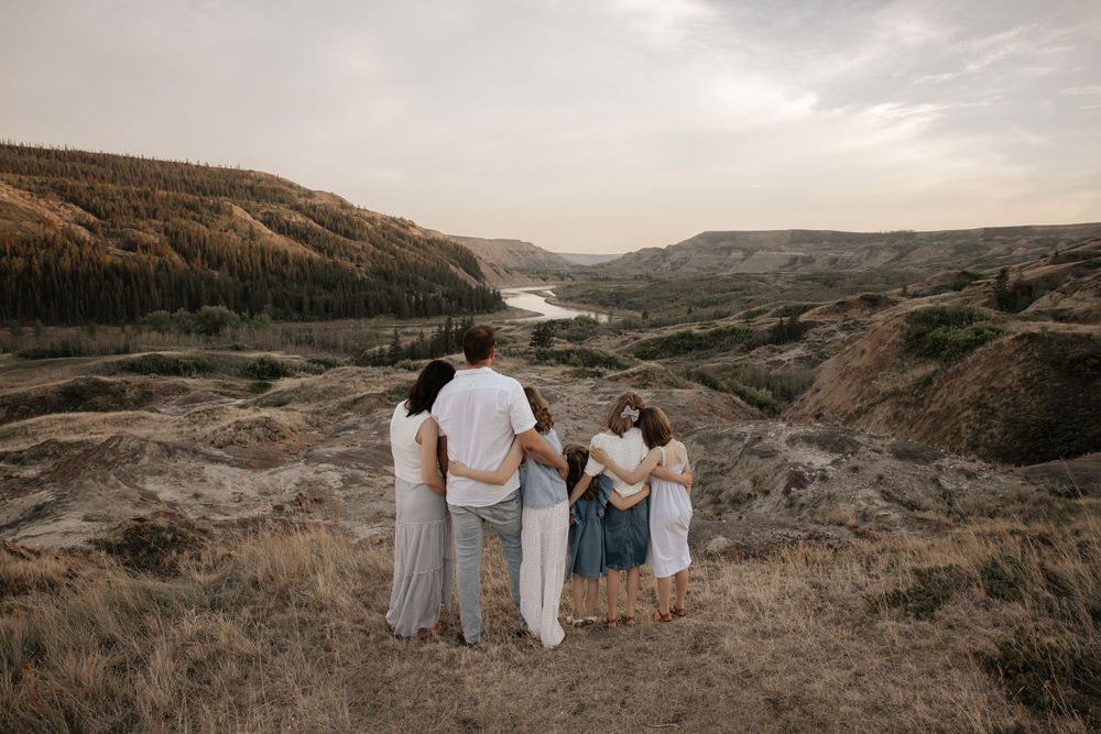 Family of five standing together on a view overlooking a scenic river valley in calgary alberta