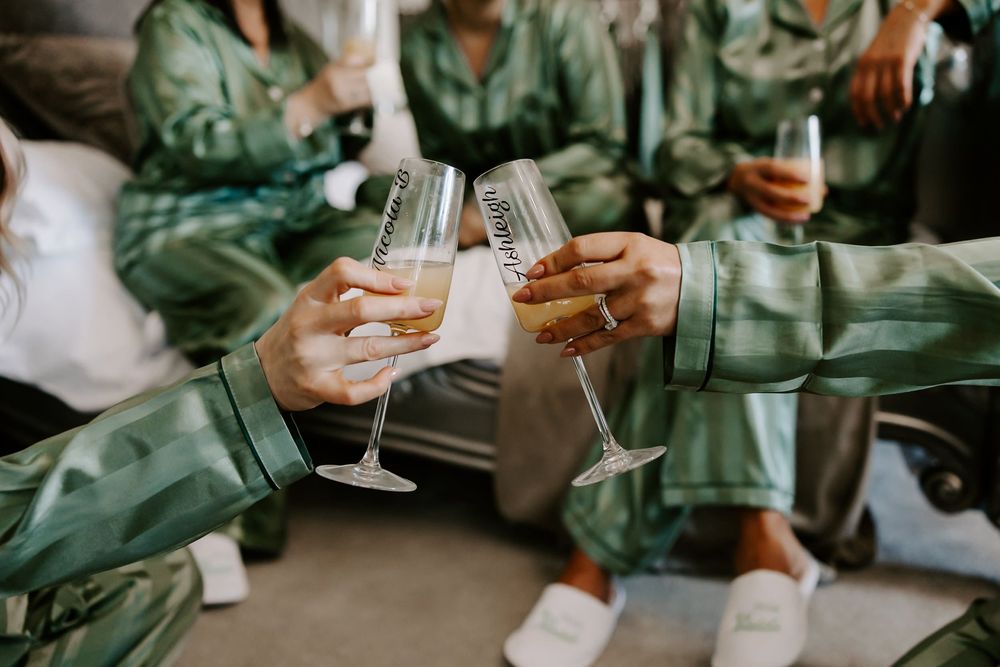 People in matching silk green robes toasting with champagne glasses during a celebration.