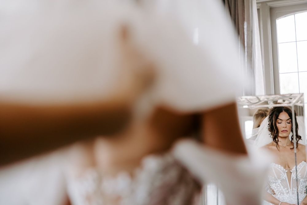 A delicate perfume bottle sits on a white surface with soft natural lighting creating an elegant composition.