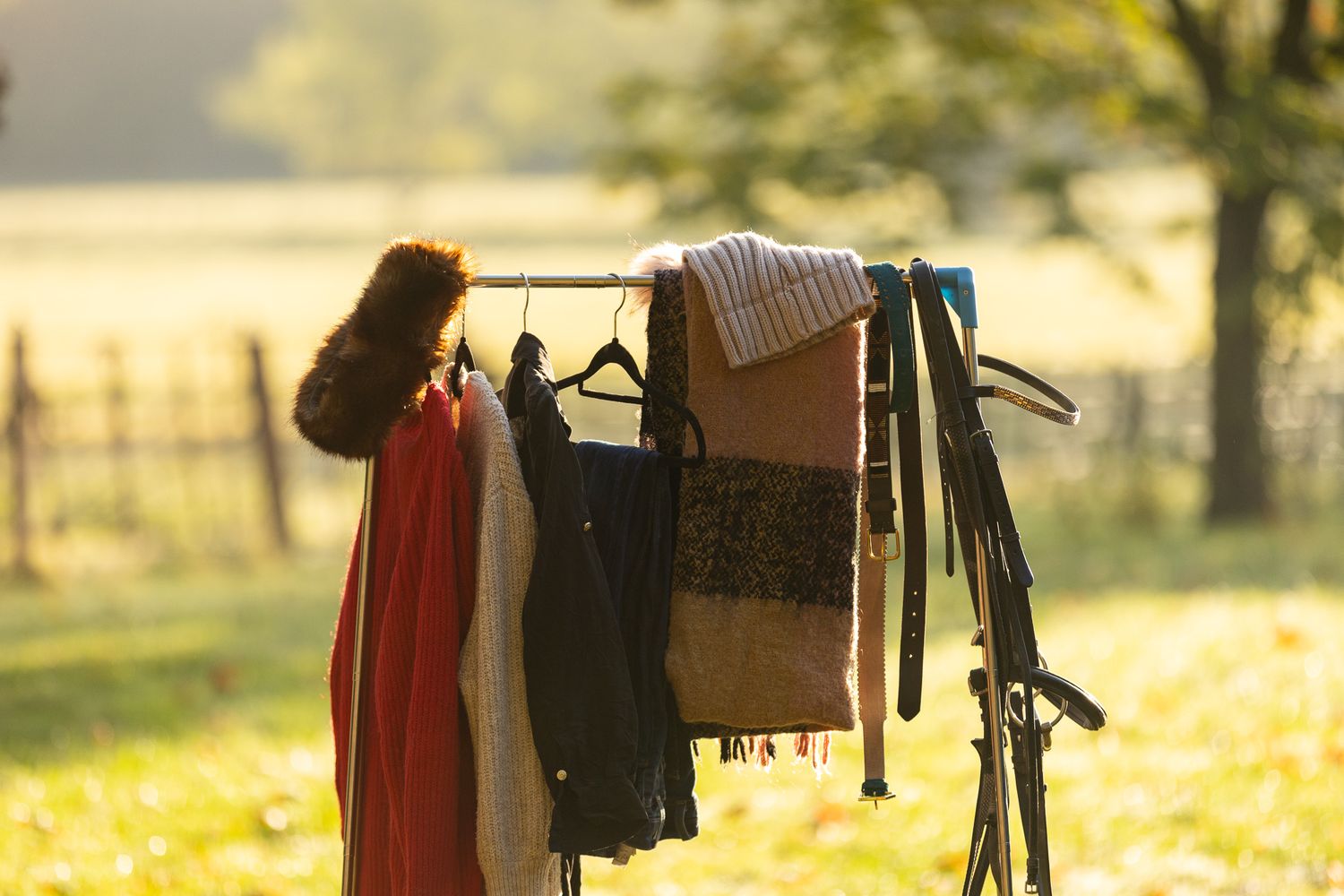Clothes hanging on a drying rack outdoors in golden sunlight with a blurred natural background.