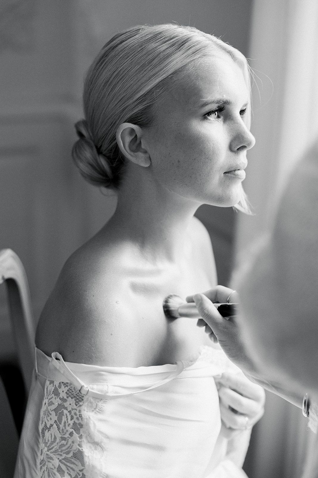 A sequence of profile shots showing makeup being applied to a person wearing a white lace dress.