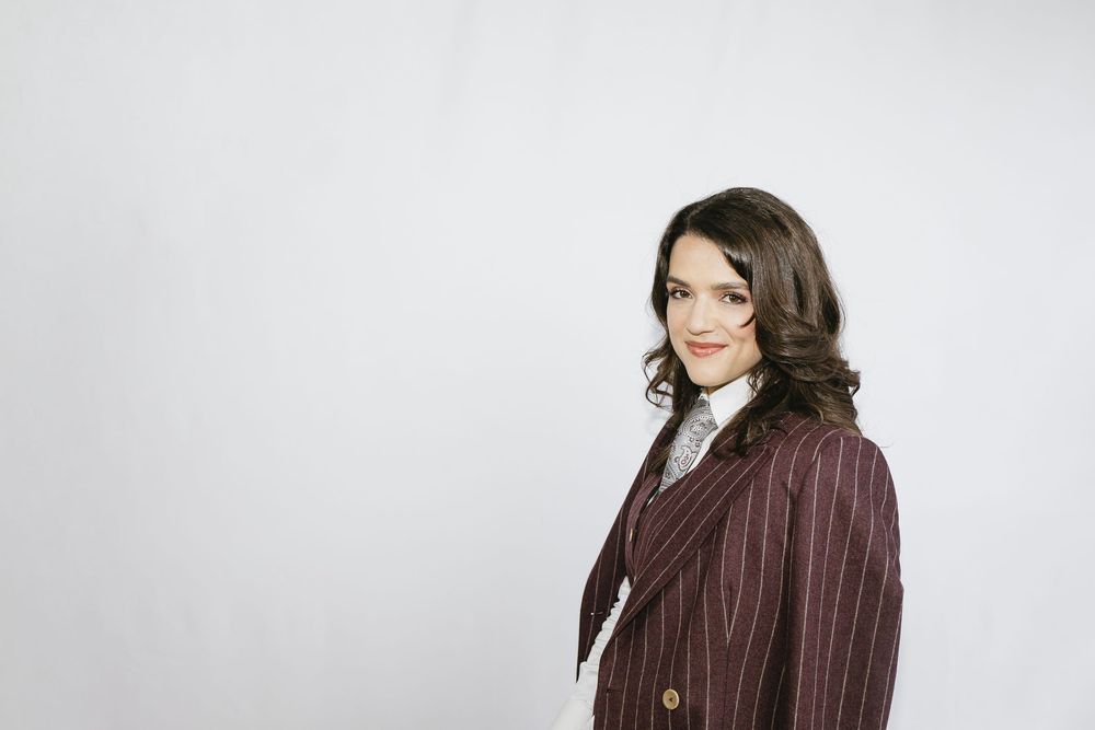 A brown pinstripe blazer shown from multiple angles against a light background.