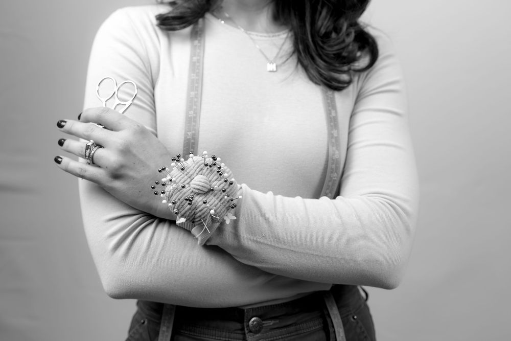 Black and white portrait series showing a person in a white top with crossed arms in different poses.