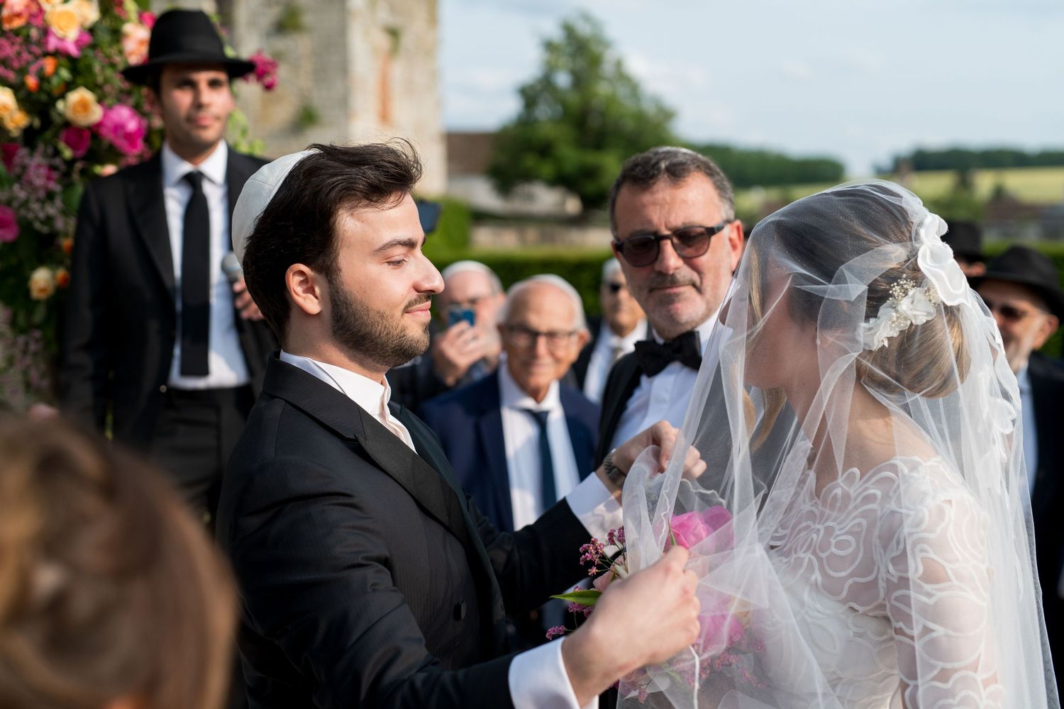 Marié déposant délicatement le voile sur le visage de la mariée pendant la cérémonie du Badeken.