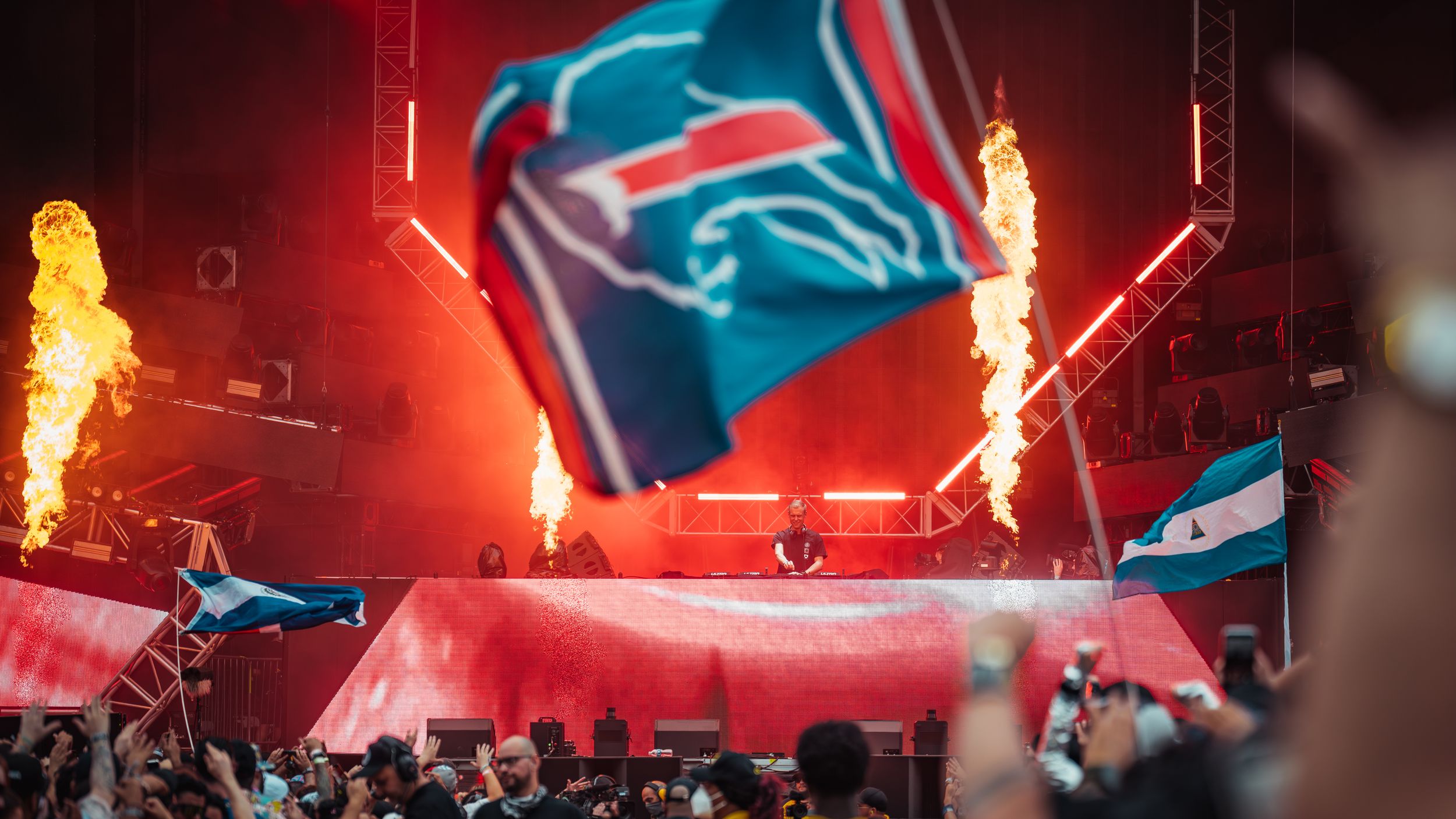 Carolina Panthers NFL logo illuminated by dramatic pyrotechnics display during stadium event with red lighting effects.